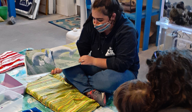 Niki reading to a Blue Ocean Discovery Center visitor