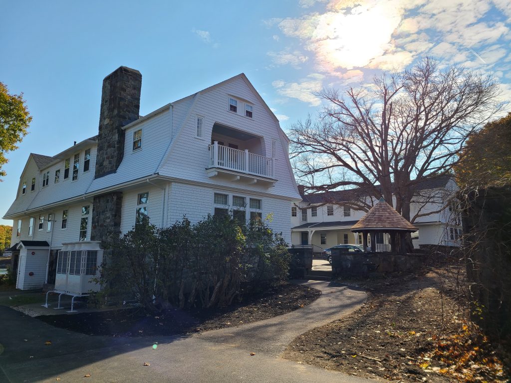 Back of Carey Cottage, a large white building with a parking lot in the foreground