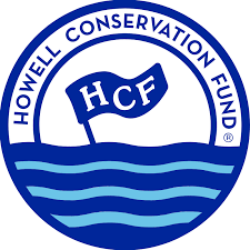 A logo featuring blue and light blue wavy lines with a blue flag sticking out of the water with the letters HCF in white